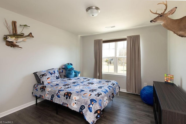 bedroom with wood finished floors, visible vents, and baseboards