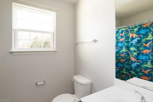 full bathroom featuring a shower with shower curtain, toilet, and vanity