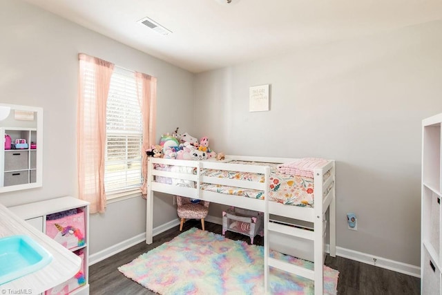 bedroom featuring wood finished floors, visible vents, and baseboards