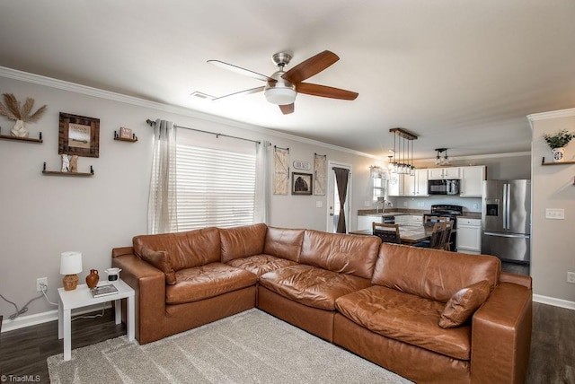 living room with visible vents, dark wood-type flooring, crown molding, baseboards, and ceiling fan