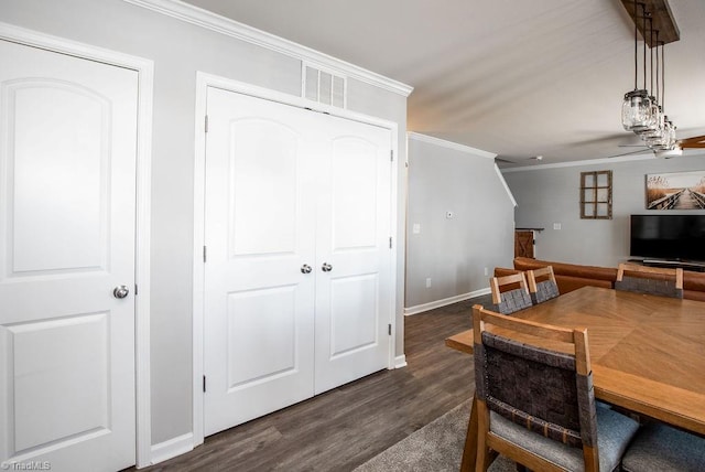 dining space featuring visible vents, baseboards, dark wood finished floors, and crown molding