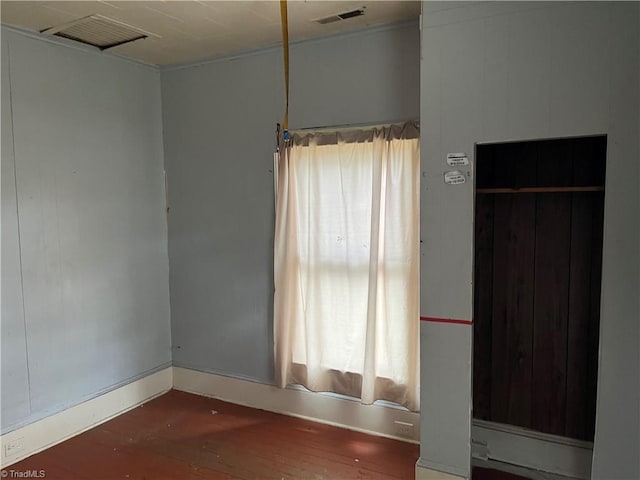 spare room featuring a wealth of natural light and dark wood-type flooring