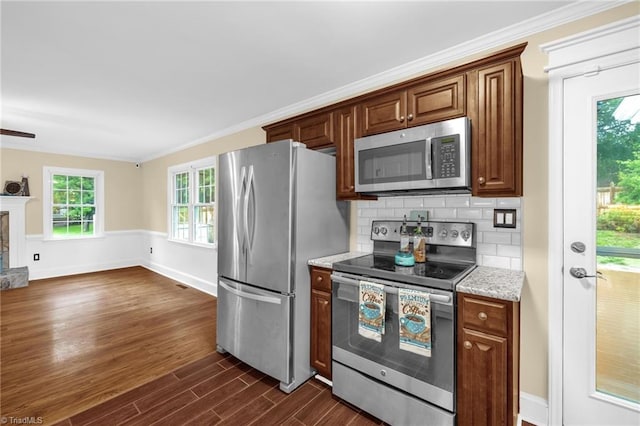 2305 Hunters Ridge Dr, Pleasant Garden, NC 27313 - kitchen featuring appliances with stainless steel finishes, dark wood-style floors, backsplash, light stone counters, and crown molding