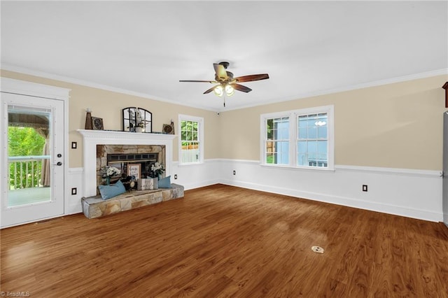 2305 Hunters Ridge Dr, Pleasant Garden, NC 27313 - unfurnished living room featuring ceiling fan, wood finished floors, crown molding, a stone fireplace, and baseboards