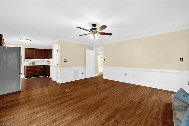 2305 Hunters Ridge Dr, Pleasant Garden, NC 27313 - unfurnished living room featuring ceiling fan, dark wood-type flooring, crown molding, and a wainscoted wall