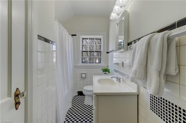 bathroom with toilet, curtained shower, tile walls, and vanity