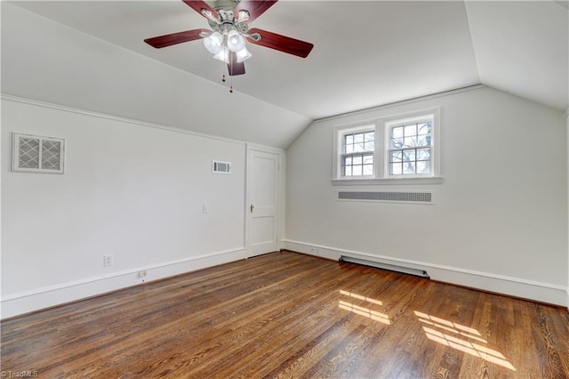 additional living space featuring visible vents, dark wood-type flooring, and vaulted ceiling