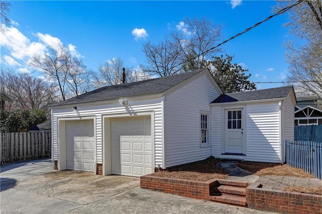 exterior space featuring a detached garage and fence