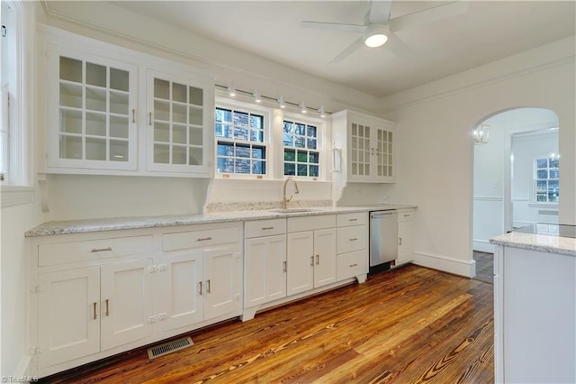 kitchen with visible vents, white cabinetry, arched walkways, a sink, and stainless steel dishwasher