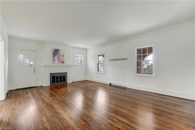 unfurnished living room featuring a glass covered fireplace, ornamental molding, and wood finished floors