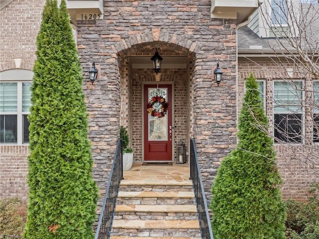 property entrance featuring stone siding and brick siding