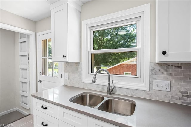 kitchen with sink, backsplash, and white cabinetry