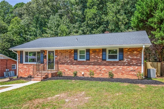 ranch-style house with central air condition unit and a front lawn