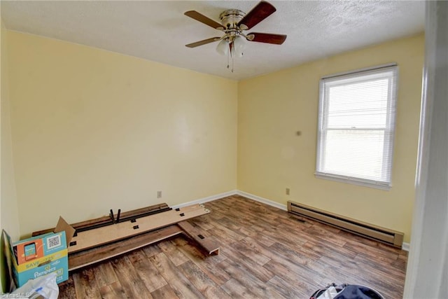 spare room with hardwood / wood-style floors, ceiling fan, a textured ceiling, and baseboard heating