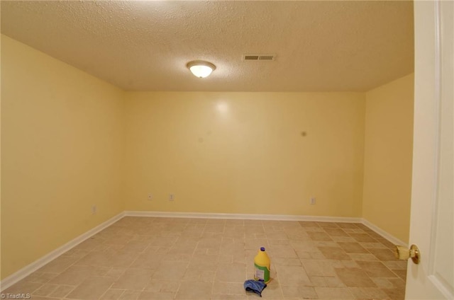 unfurnished room featuring a textured ceiling