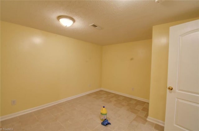 unfurnished room featuring a textured ceiling