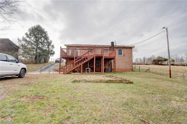 back of property featuring a yard and a deck