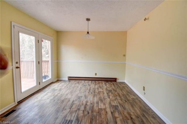 unfurnished dining area with baseboard heating and hardwood / wood-style floors