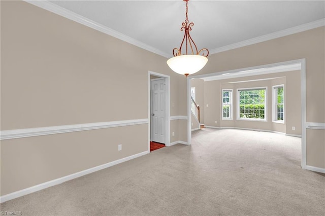 carpeted spare room featuring crown molding, baseboards, and stairs