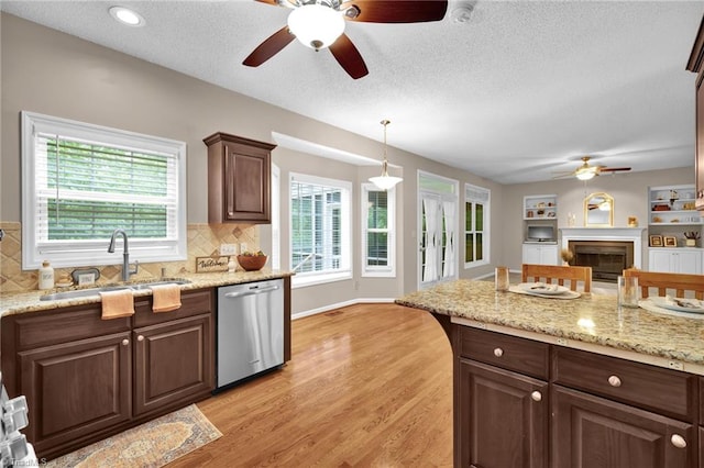 kitchen with dishwasher, ceiling fan, a sink, plenty of natural light, and a textured ceiling