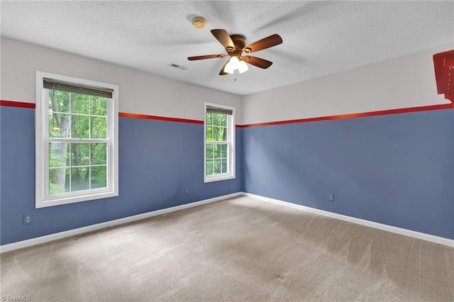 unfurnished room featuring carpet floors, a ceiling fan, baseboards, and a textured ceiling