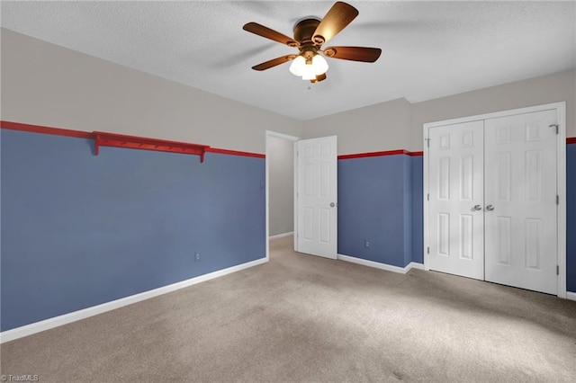unfurnished bedroom featuring carpet flooring, baseboards, a closet, and a textured ceiling