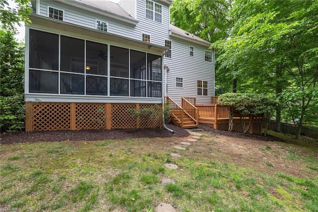 rear view of property featuring a sunroom and a deck