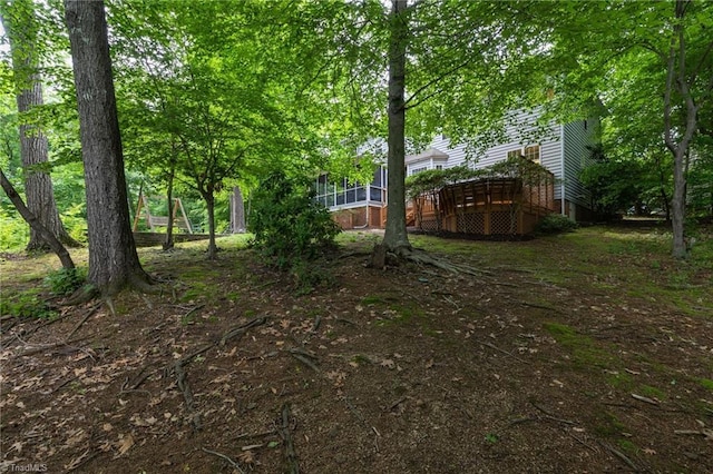 view of yard with a wooden deck and a sunroom