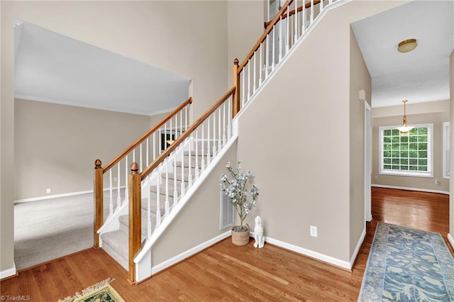 stairs featuring wood finished floors and baseboards