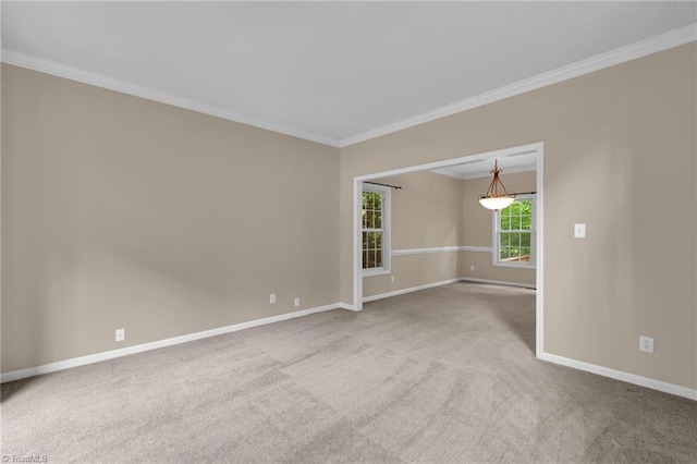 carpeted empty room featuring baseboards and crown molding
