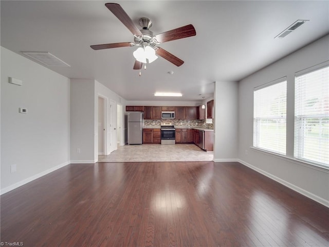 unfurnished living room with ceiling fan, wood-type flooring, and sink