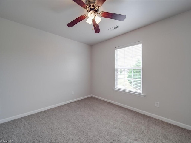 carpeted spare room featuring ceiling fan