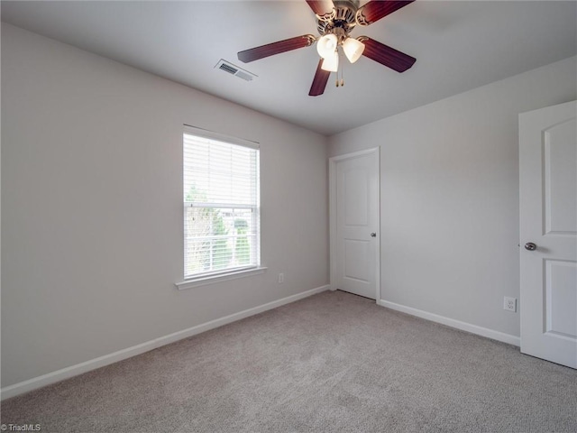 spare room featuring ceiling fan and light carpet