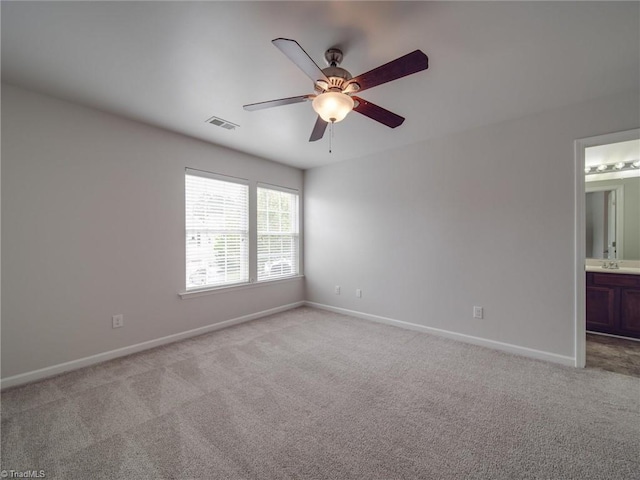 unfurnished room featuring light colored carpet and ceiling fan