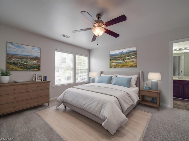 carpeted bedroom featuring connected bathroom and ceiling fan