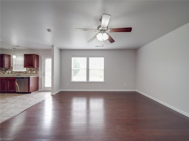 unfurnished living room featuring ceiling fan, dark hardwood / wood-style flooring, and sink