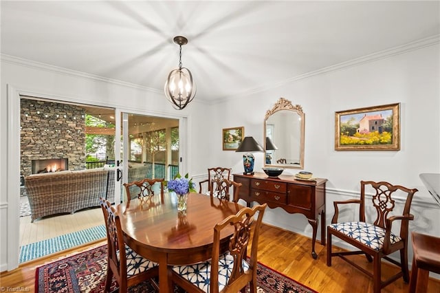 5017 Timbrook Ln, Winston-Salem, NC 27103 - dining space with wood finished floors, a chandelier, ornamental molding, and a fireplace