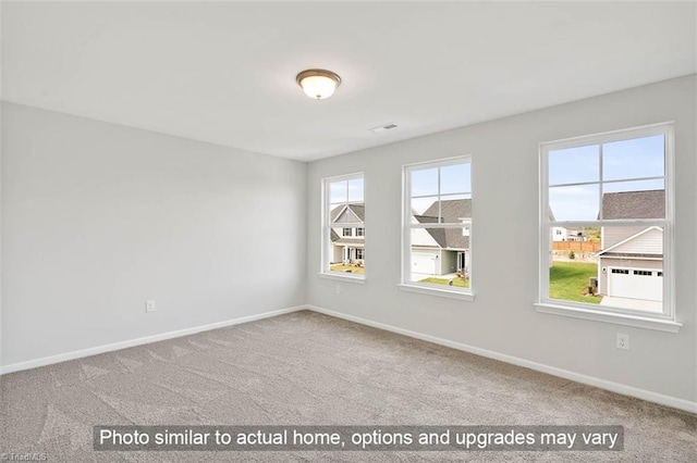 unfurnished room featuring carpet and baseboards