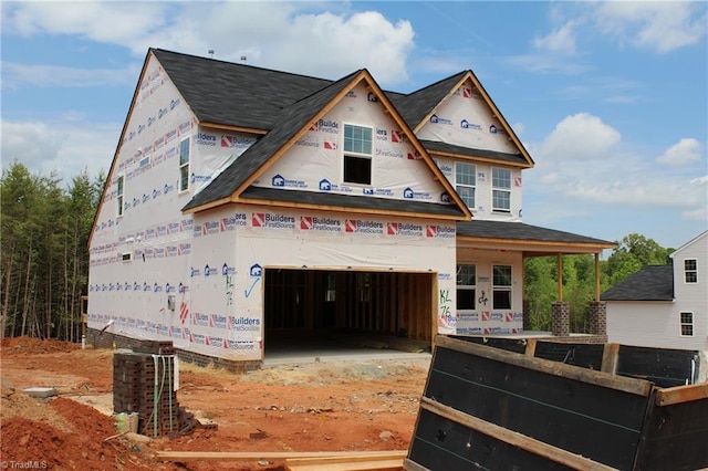property in mid-construction featuring a garage, a shingled roof, and cooling unit