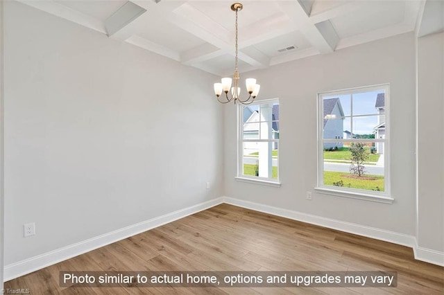 spare room featuring coffered ceiling, wood finished floors, baseboards, a chandelier, and beamed ceiling