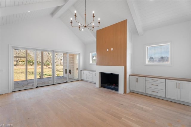 unfurnished living room with beamed ceiling, a notable chandelier, high vaulted ceiling, and light hardwood / wood-style flooring