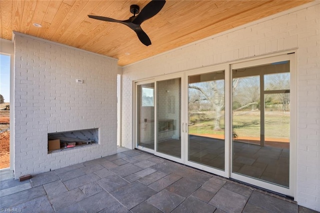 view of patio / terrace with ceiling fan and a brick fireplace