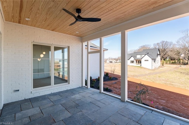 unfurnished sunroom featuring wooden ceiling and ceiling fan