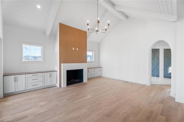 unfurnished living room with high vaulted ceiling, light hardwood / wood-style flooring, a notable chandelier, beamed ceiling, and a fireplace