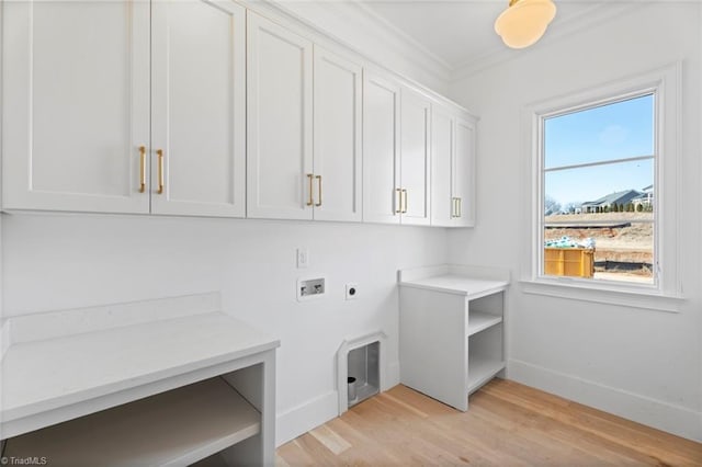 clothes washing area with crown molding, hookup for a washing machine, cabinets, light hardwood / wood-style floors, and hookup for an electric dryer