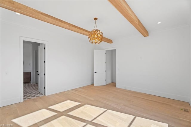 empty room featuring beam ceiling and hardwood / wood-style floors