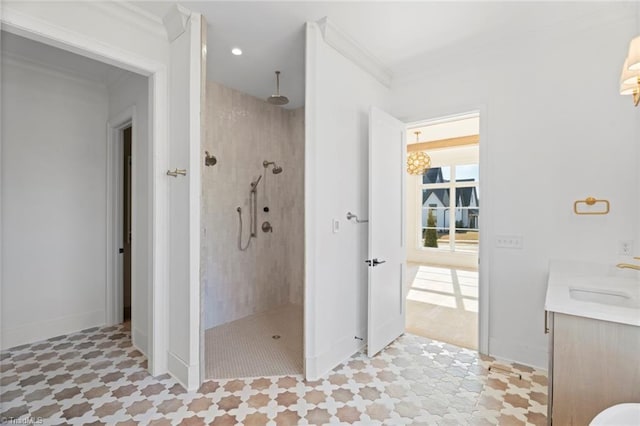 bathroom with crown molding, tiled shower, and vanity