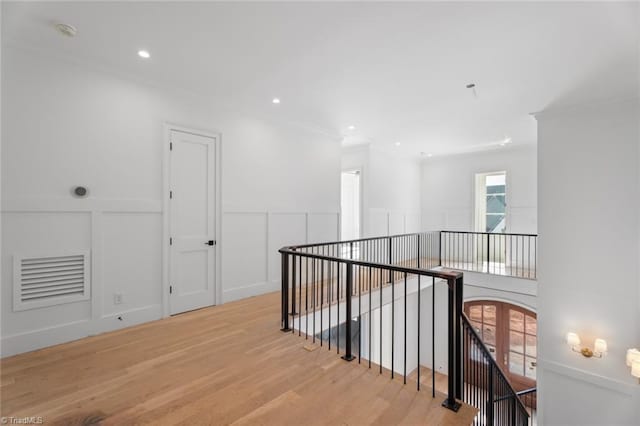 hall featuring light hardwood / wood-style flooring and crown molding