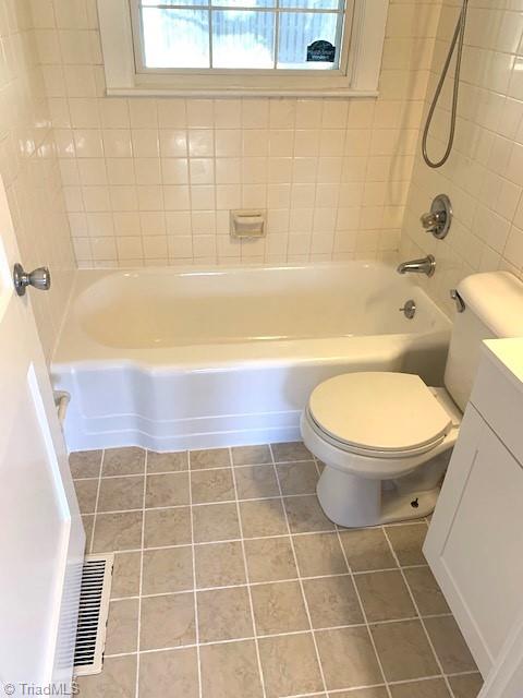 full bathroom featuring tile patterned floors, vanity, toilet, and tiled shower / bath