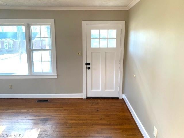 doorway to outside with crown molding, plenty of natural light, and dark wood-type flooring